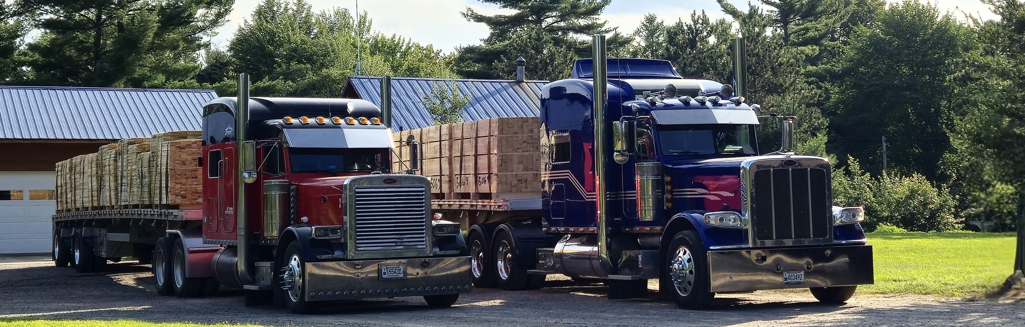 Picture of 2 trucks one red the other blue loaded with lumber